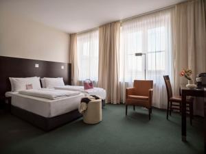 a bedroom with a bed and a desk and a chair at Flemings Hotel München-City in Munich