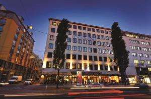 a large building on a city street at night at Flemings Hotel München-City in Munich