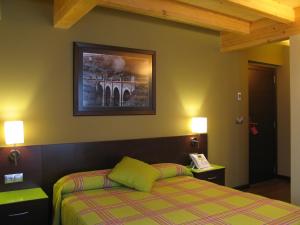 1 dormitorio con 1 cama y una foto en la pared en Hotel Rolle, en Ribadeo