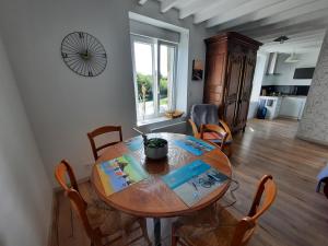a dining room with a wooden table and chairs at GITE CHEZ BERTHE in Pontfarcy