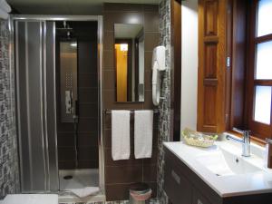 a bathroom with a shower and a sink and a mirror at Hotel Rolle in Ribadeo