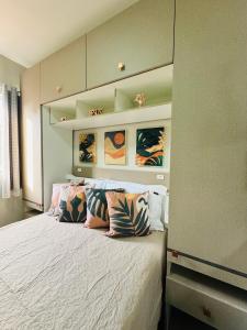 a bedroom with a bed with pillows on it at Stúdio equipado em Xerém - St 7 in Xerém +23 photos