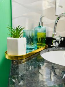 a bathroom with a sink and two glasses on a counter at Stúdio equipado em Xerém - St 7 in Xerém