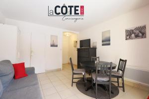 a living room with a table and chairs and a couch at le mas in La Pastissière