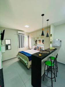a bedroom with a bed and a desk with two stools at Stúdio equipado em Xerém - St 7 in Xerém
