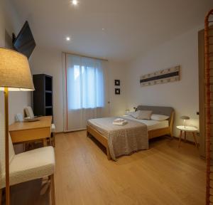 a bedroom with a bed and a table and a desk at Interno 711 in Udine
