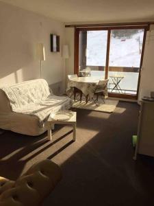 a living room with a couch and a table at A 5 étage des pistes !!! Le corbier in Le Corbier