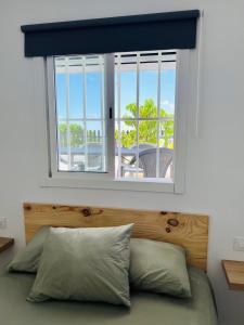 a bedroom with a window and a bed with pillows at Casa Gabi in La Sabinita