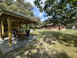 a patio with a table and chairs under a pavilion at La bergerie de lesbordes in Lestajaou +10 photos