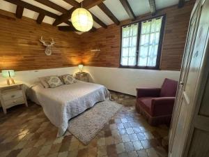 a bedroom with a bed and a chair in a room at La bergerie de lesbordes in Lestajaou