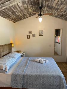 a bedroom with a bed with two towels on it at Morada do Sol Guest House in Búzios