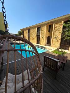 a swinging bed on a deck next to a pool at Volakas Beachfront Suites in Rethymno