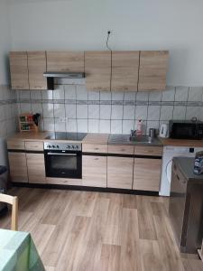 eine Küche mit Holzschränken und einem Herd in der Unterkunft 3 Zimmer Ferien & Monteurwohnung 1 Etage in Riedstadt