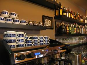a bar with blue and white cups and bottles at Hotel Rolle in Ribadeo