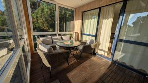 a screened in porch with a table and chairs at Taikos 7 in Nida