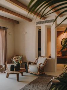 a living room with two chairs and a table at The Wild by Interni in Kalafatis