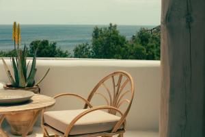 a table and chairs on a balcony with a view of the ocean at The Wild by Interni in Kalafatis