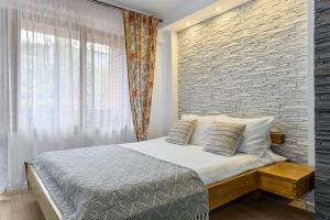 a bedroom with a bed and a brick wall at Studio Enis in Poiana Brasov