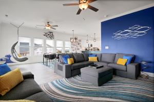 een woonkamer met een bank en een blauwe muur bij Oceanside Oasis by Sea Scape Properties in North Topsail Beach