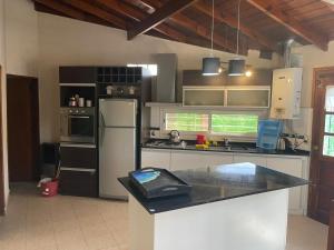 a kitchen with a refrigerator and a counter top at la Casita del bosque in Villa Gesell