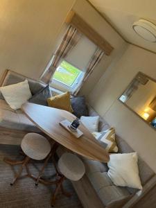 a living room with a surfboard on top of a couch at Seaside Caravan Retreat in Craig Tara in Ayr