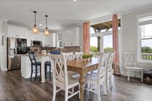 a kitchen and dining room with a wooden table and chairs at Oshun by Sea Scape Properties in Surf City
