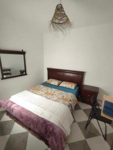 a bedroom with a bed and a mirror on the wall at Dar lmedina in Essaouira