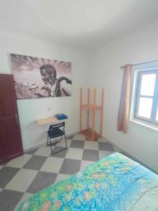 a bedroom with a bed and a desk and a window at Dar lmedina in Essaouira +1 photo