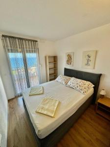 トロギールにあるApartmani Cubelaのベッドと大きな窓のある寝室