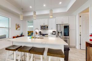 a kitchen with a large white island with bar stools at Bliss Bungalow in Cape Coral