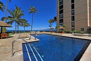 a pool at a resort with palm trees and a building at Mahana 813 in Kahana +24 photos
