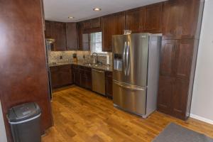 Una cocina con refrigerador de acero inoxidable y gabinetes de madera. en Mark and Faiths Lake House, en Worthville