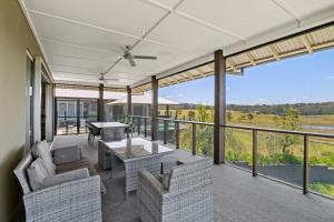 a screened in porch with a table and chairs at Mountain Majesty with Poolside Relaxing Getaway in Tamborine