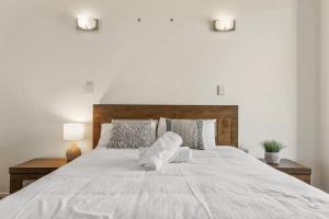 a large white bed with two pillows on it at Mountain Majesty with Poolside Relaxing Getaway in Tamborine