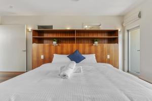 a large white bed with a towel on it at Mountain Majesty with Poolside Relaxing Getaway in Tamborine
