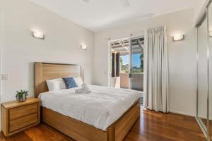 a bedroom with a large bed and a balcony at Mountain Majesty with Poolside Relaxing Getaway in Tamborine