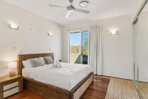 a bedroom with a large bed and a window at Mountain Majesty with Poolside Relaxing Getaway in Tamborine