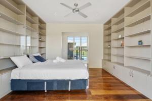a bedroom with a large bed and shelves at Mountain Majesty with Poolside Relaxing Getaway in Tamborine