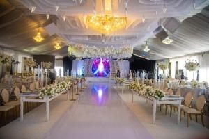 a banquet hall with white tables and chairs and chandeliers at Golden Tulip Hotel -GT31 Stadium Road in Port Harcourt +27 photos
