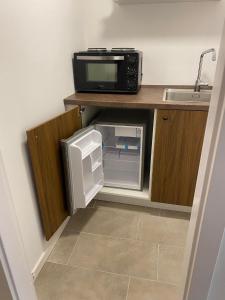 a small kitchen with a microwave and a small refrigerator at Bed minus breakfast Den hyggelige kælder in Nykøbing Falster