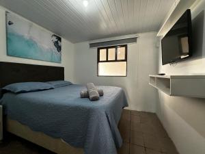 una camera da letto con un letto e una TV a parete di BS01- Casa com Piscina Aquecida e Churrasqueira a Balneário Barra do Sul Altre 57 foto