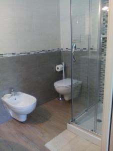 a bathroom with a toilet and a glass shower at B & B La Magnolia in Specchiolla