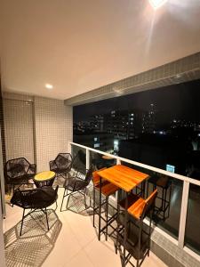 a balcony with a table and chairs and a view of the city at RN STUDIO PREMIUM Ap 321 in Maceió