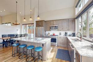 una cocina con una gran isla con taburetes de barra azul en Flat Tops 2510, en Steamboat Springs