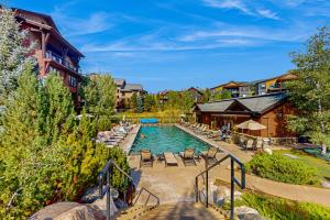 Una piscina con sillas y un resort. en Flat Tops 2510, en Steamboat Springs