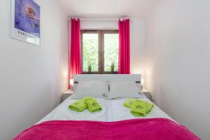 a bedroom with a large bed with pink curtains at Górzysty I in Karpacz
