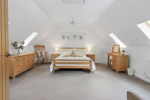 a bedroom with a bed and two tables and a chair at Stunning cottage with hot tub in Marldon