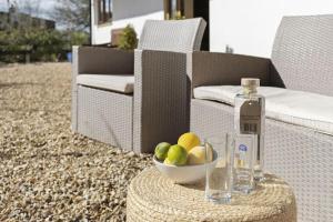 a bottle of alcohol and a bowl of fruit on a table at Stunning cottage with hot tub in Marldon