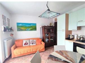 a living room with an orange couch in a kitchen at La casa dei sentieri in Rovetta