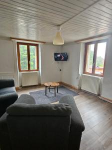 a living room with a couch and a tv at relais de la diligence in Morteau